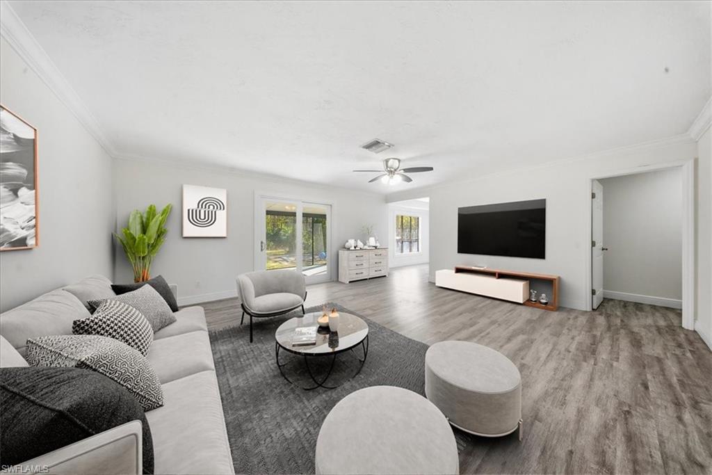 Living room featuring wood finished floors, ornamental molding, and a ceiling fan