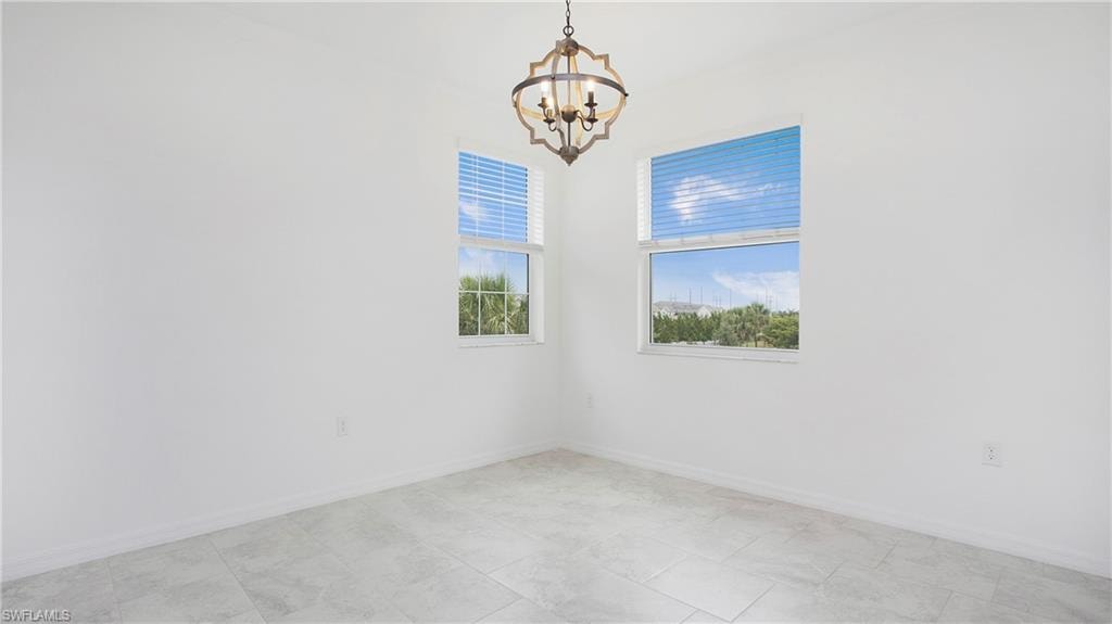 Tray ceiling featuring a decorative chandelier with iron and wood-finish accents