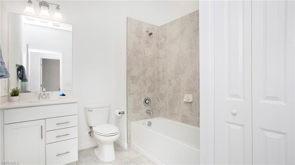 Bathroom with white vanity, integrated sink, and chrome fixtures