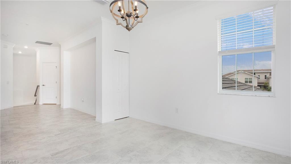 Spacious interior featuring light-colored tile flooring, white walls, and a large window with horizontal blinds