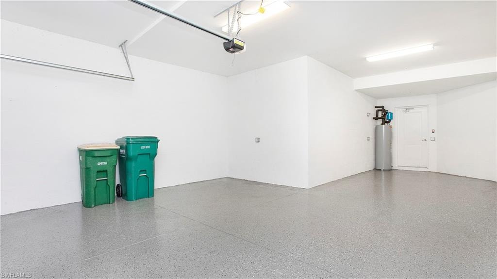 Spacious garage with light grey speckled epoxy flooring and bright overhead fluorescent lighting