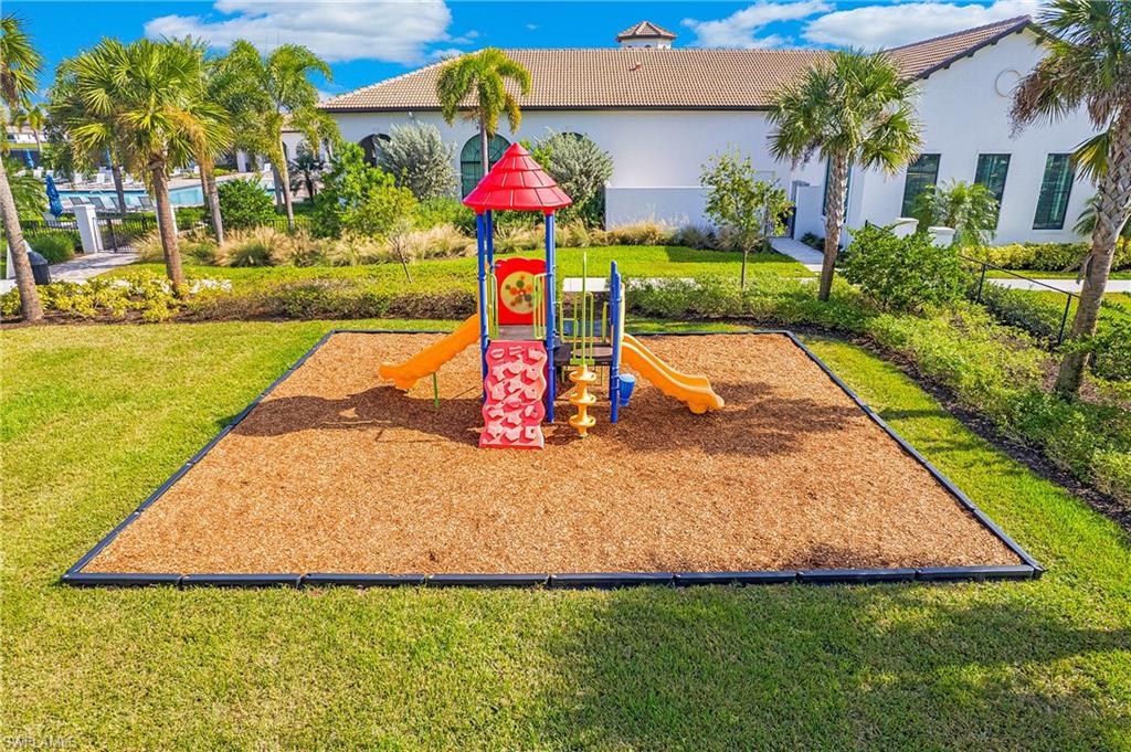 Recreational playground featuring a slide, climbing steps, and a turfed area with wood chip surfacing