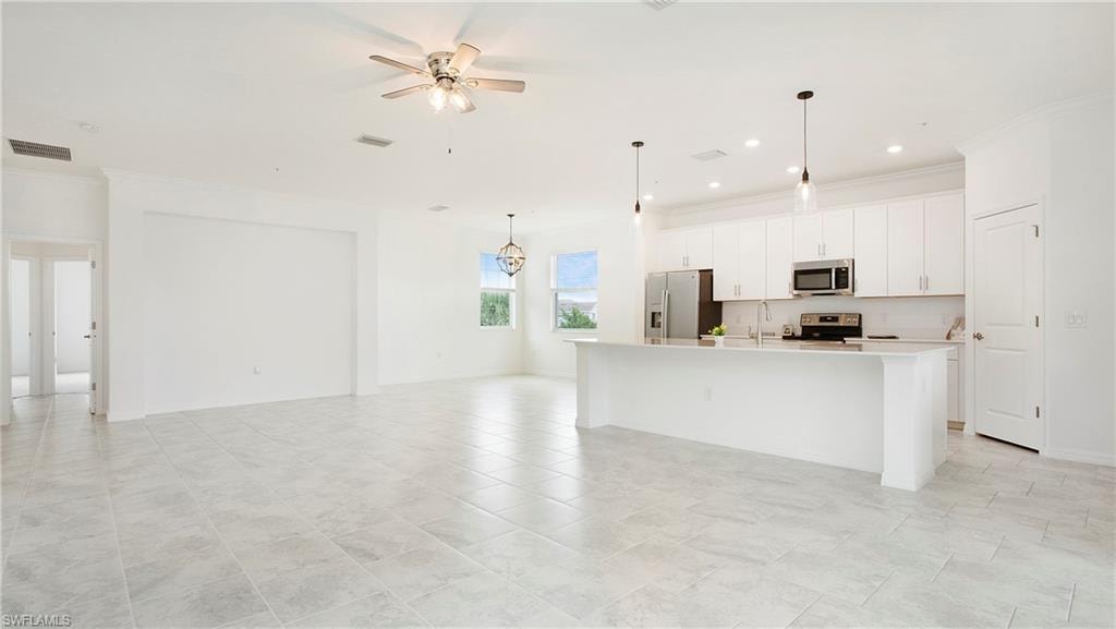 Open-concept living area featuring light-toned tile flooring throughout