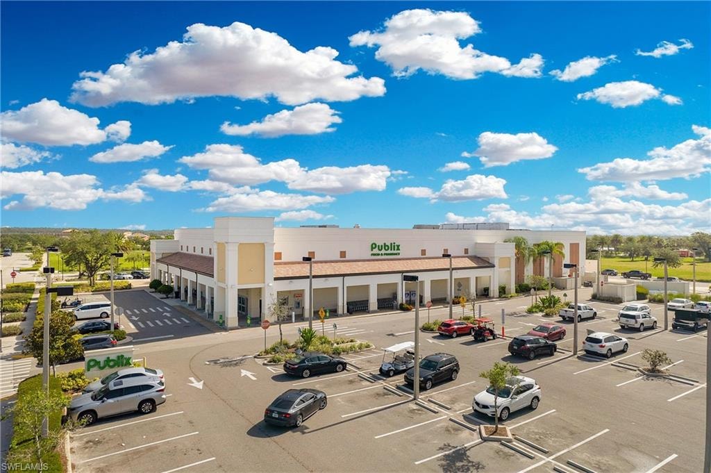 Publix grocery store with a large parking lot, multiple storefronts, and a wide entryway