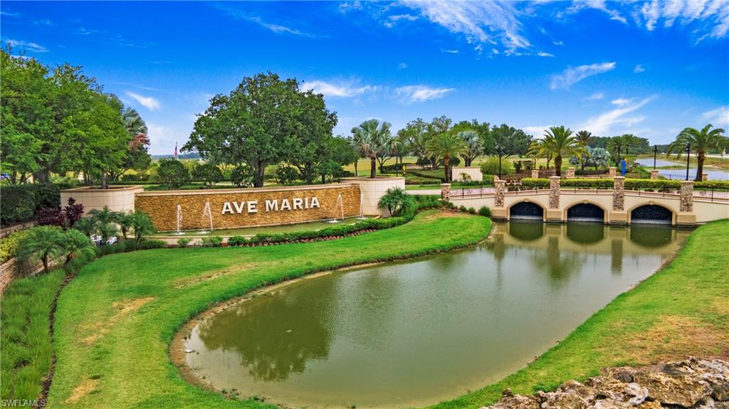 Lush landscaping surrounds a prominent community entrance monument with water features