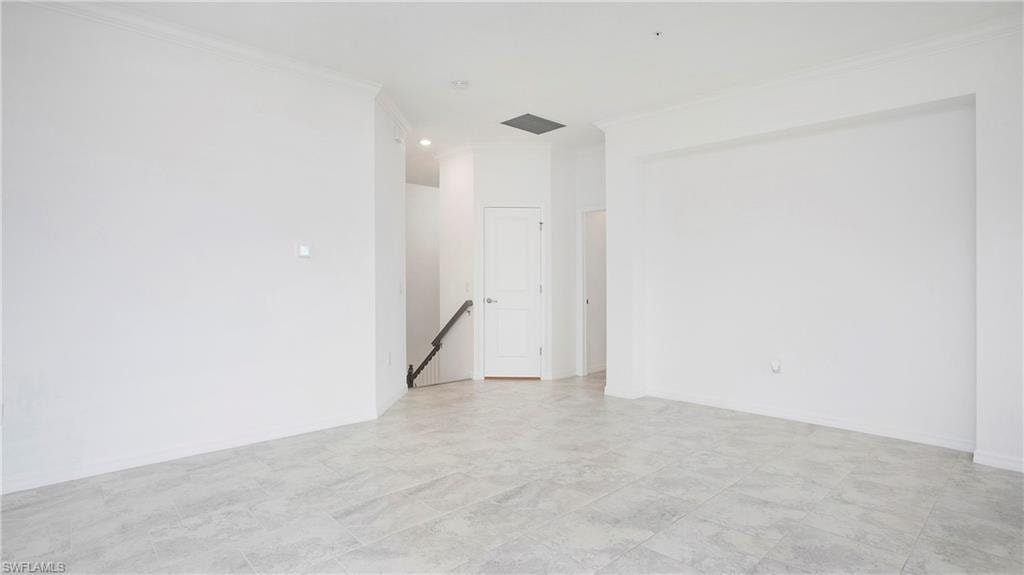 Open-concept living space featuring light-toned tile flooring, recessed lighting, and crisp white walls
