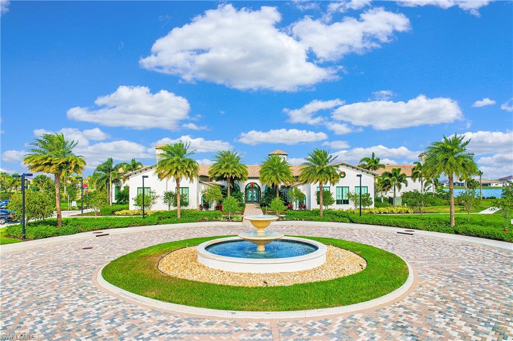 Expansive paver-patterned circular driveway with a central tiered water fountain