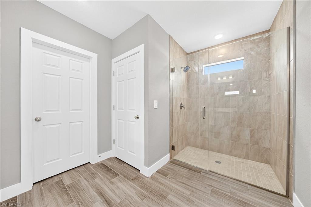 Full bath with a stall shower and wood finish floors