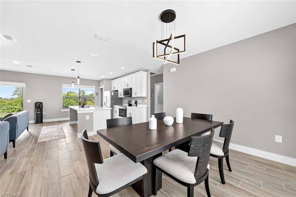 Dining area with wood tiled floors, a chandelier, and recessed lighting