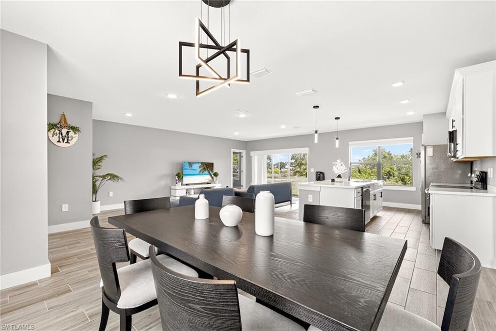 Dining space with wood finish floors, recessed lighting, and a chandelier