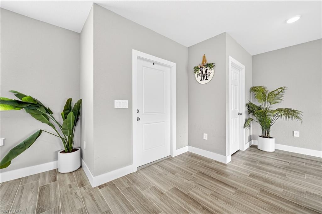 Entryway featuring baseboards and wood finish floors