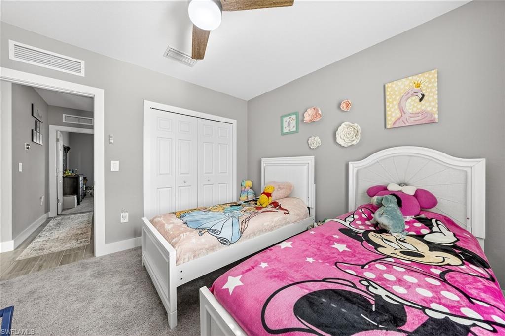 Bedroom featuring a closet, a ceiling fan, and light carpet