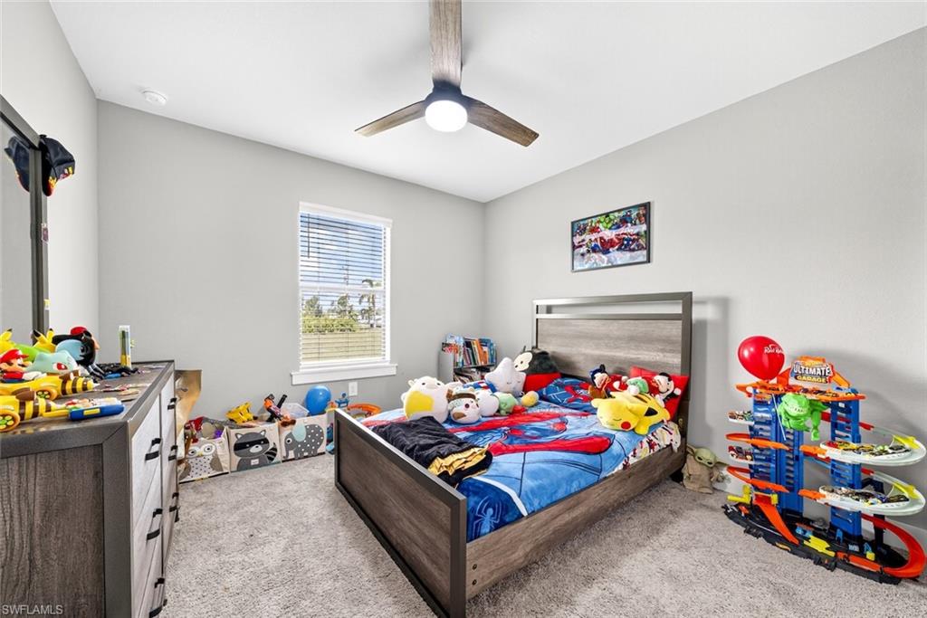 Bedroom featuring light carpet and a ceiling fan