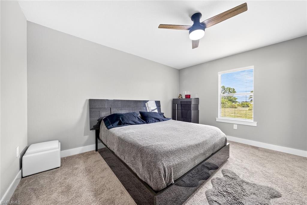 Carpeted bedroom with baseboards and ceiling fan