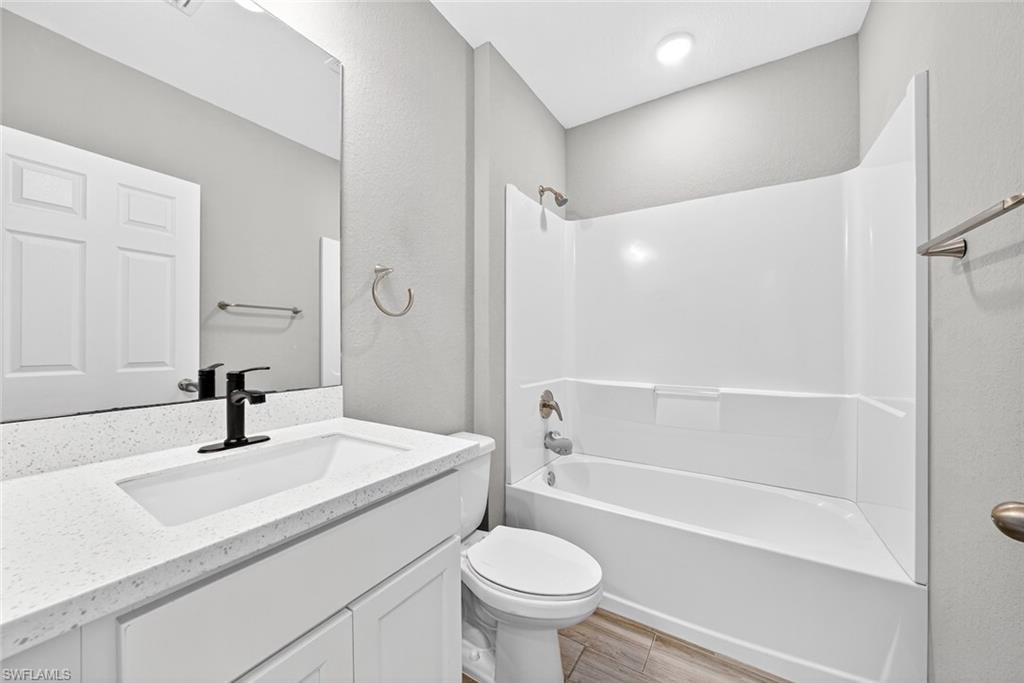 Full bathroom featuring bathtub / shower combination, vanity, and wood finish floors