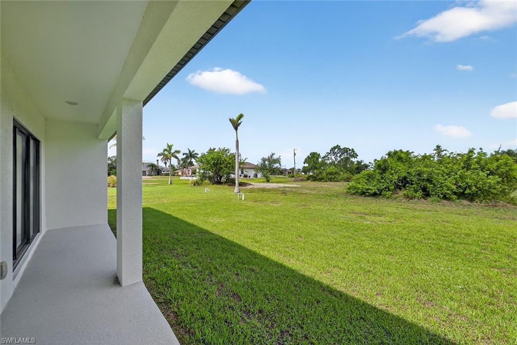 View of green lawn with a patio area