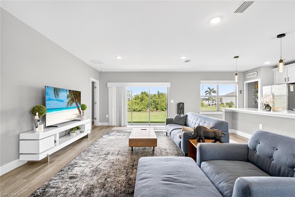 Living room with light wood-style floors and recessed lighting