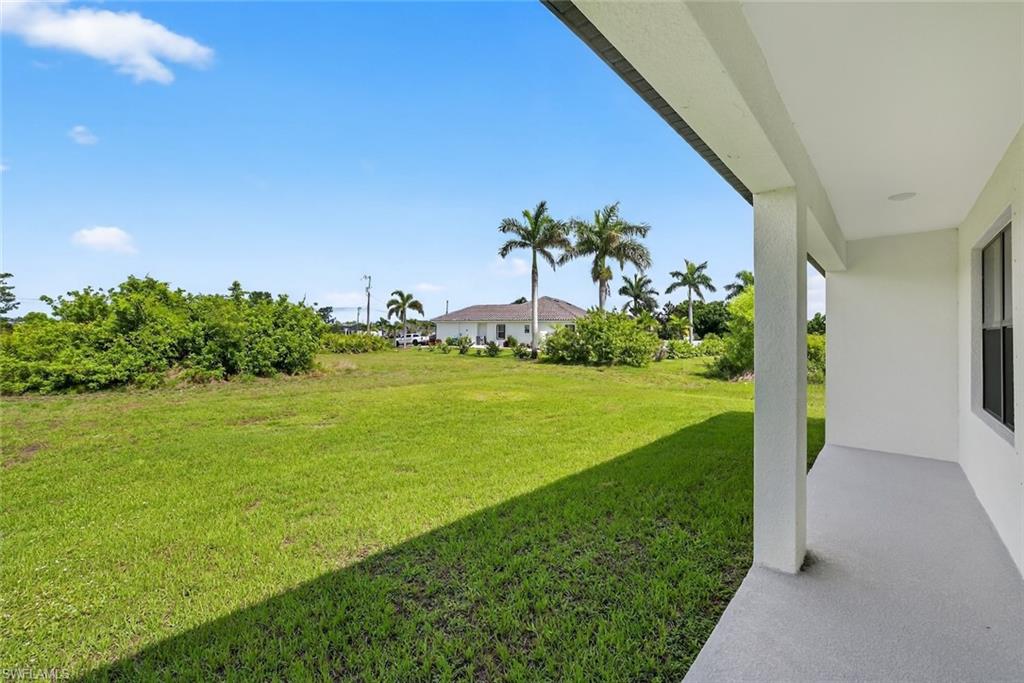 View of grassy yard featuring a patio area