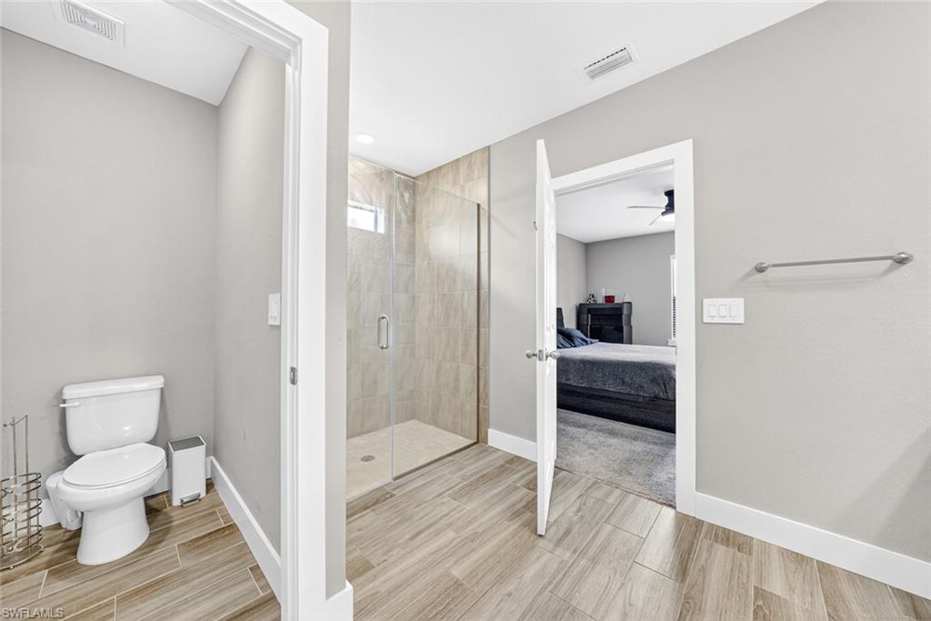 Bathroom with ensuite bathroom, a shower stall, and wood tiled floors
