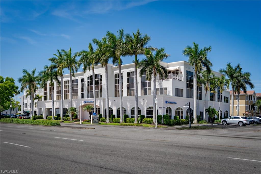 Contemporary commercial building featuring a white facade and arched ground-floor windows