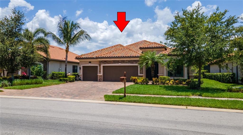 Mediterranean / spanish home featuring a garage and a front lawn