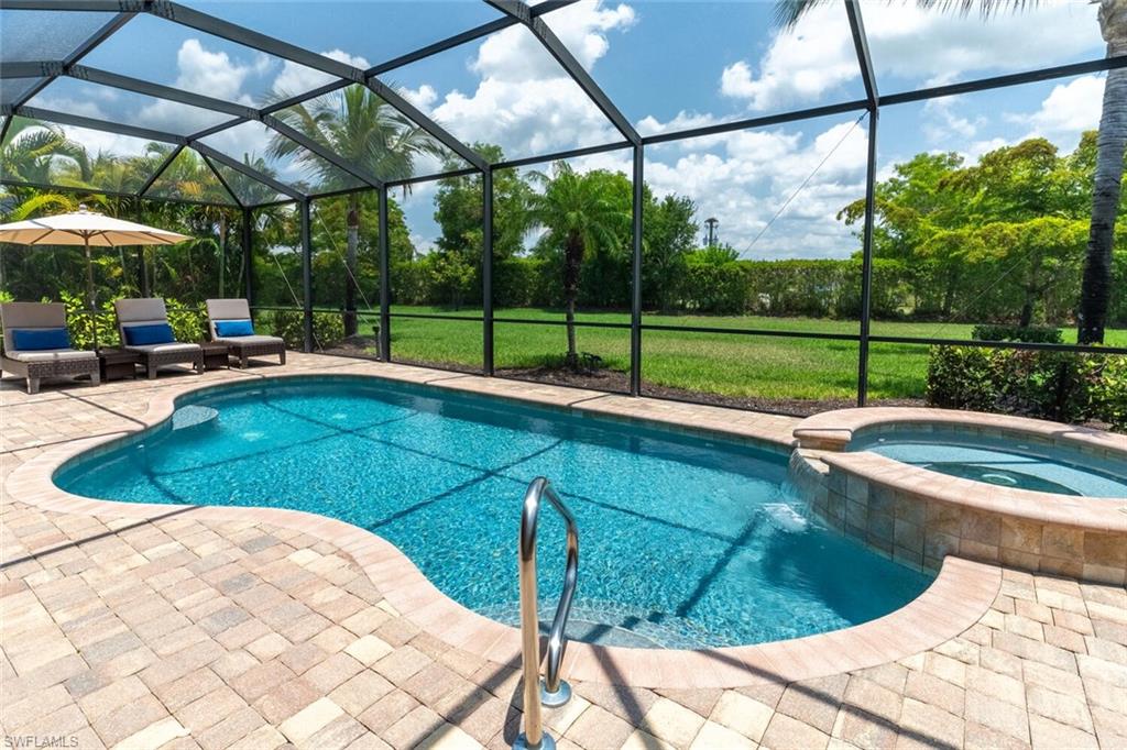 View of pool featuring glass enclosure, an in ground hot tub, and a patio area