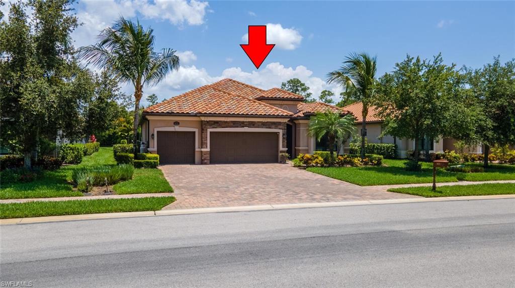 Mediterranean / spanish-style home featuring a front yard and a garage