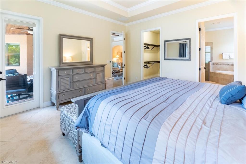 Tiled bedroom featuring a spacious closet, a closet, connected bathroom, and ornamental molding