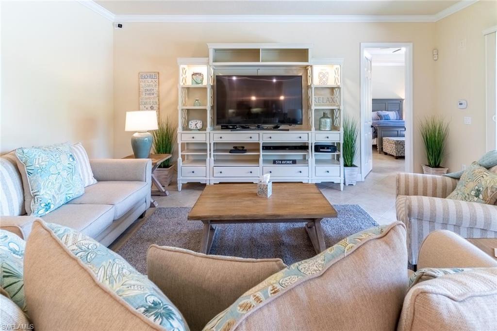 Tiled living room featuring crown molding