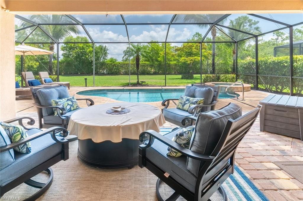 View of swimming pool featuring a patio, a lanai, and a lawn