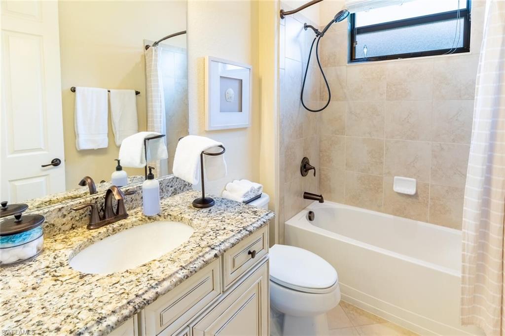 Full bathroom featuring shower / bath combo, tile patterned floors, vanity, and toilet