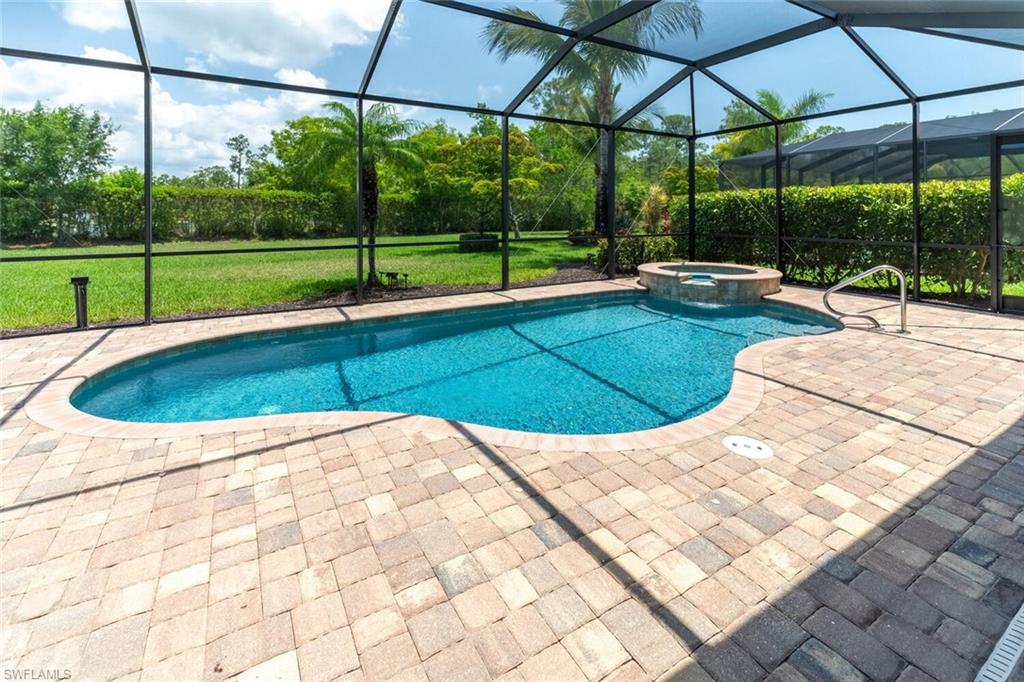 View of pool featuring a patio, an in ground hot tub, a lanai, and a yard
