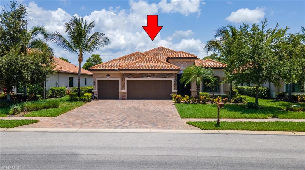 Mediterranean / spanish house featuring a front lawn and a garage