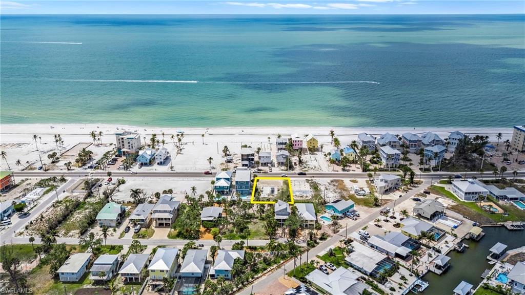 Drone / aerial view featuring a water view, a residential view, and a view of the beach  - Virtually Edited Image
