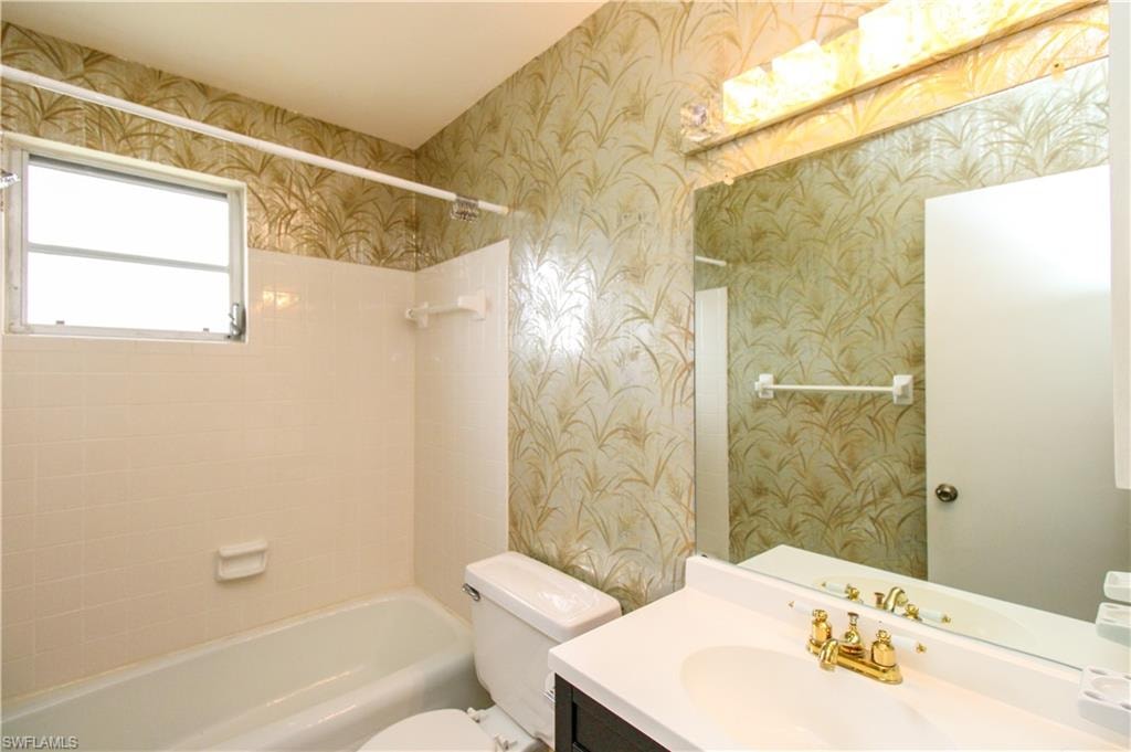 Full bathroom featuring vanity, tiled shower / bath, and toilet