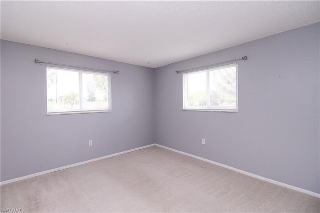 Empty room with carpet floors and plenty of natural light