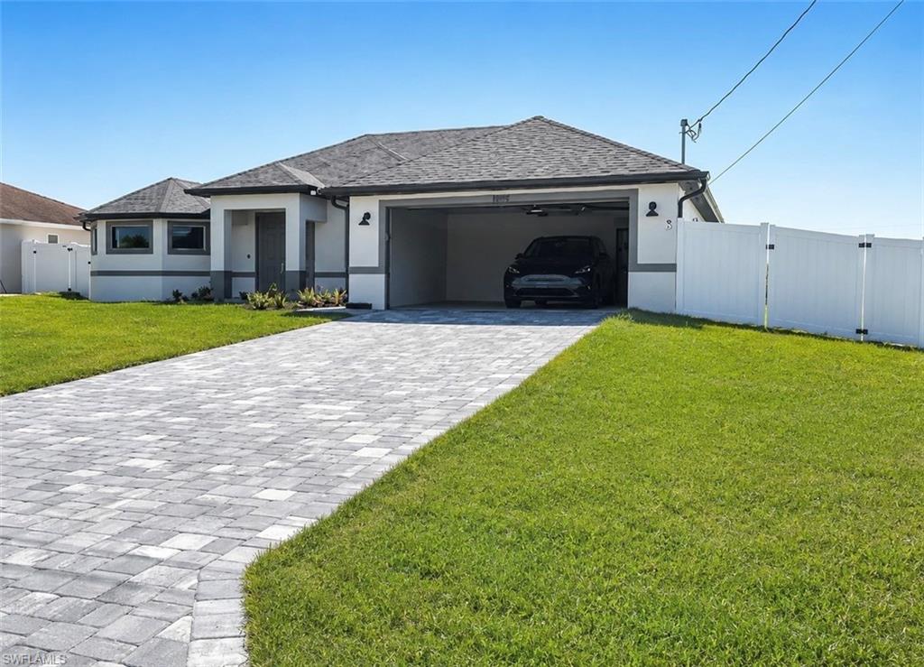 Contemporary ranch-style residence featuring a gray shingle roof and a two-tone stucco exterior