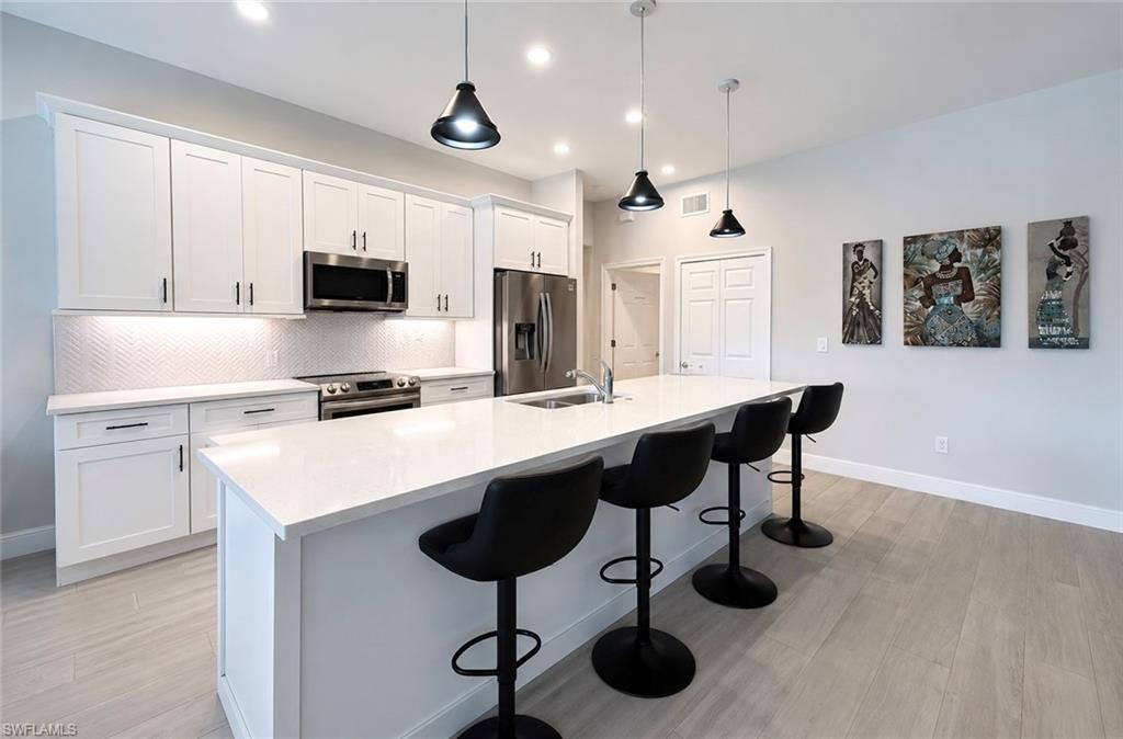 Modern kitchen with white cabinetry and stainless steel appliances