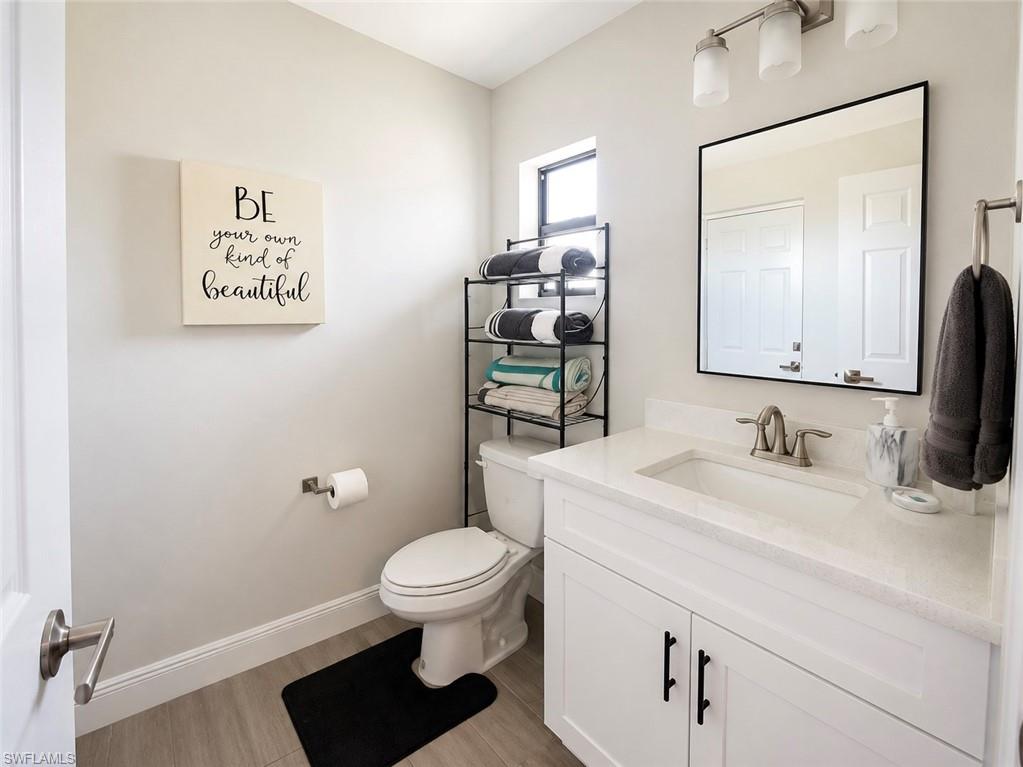 Spa-inspired bathroom featuring a white vanity with dual cabinet storage, quartz countertop, and brushed nickel faucet