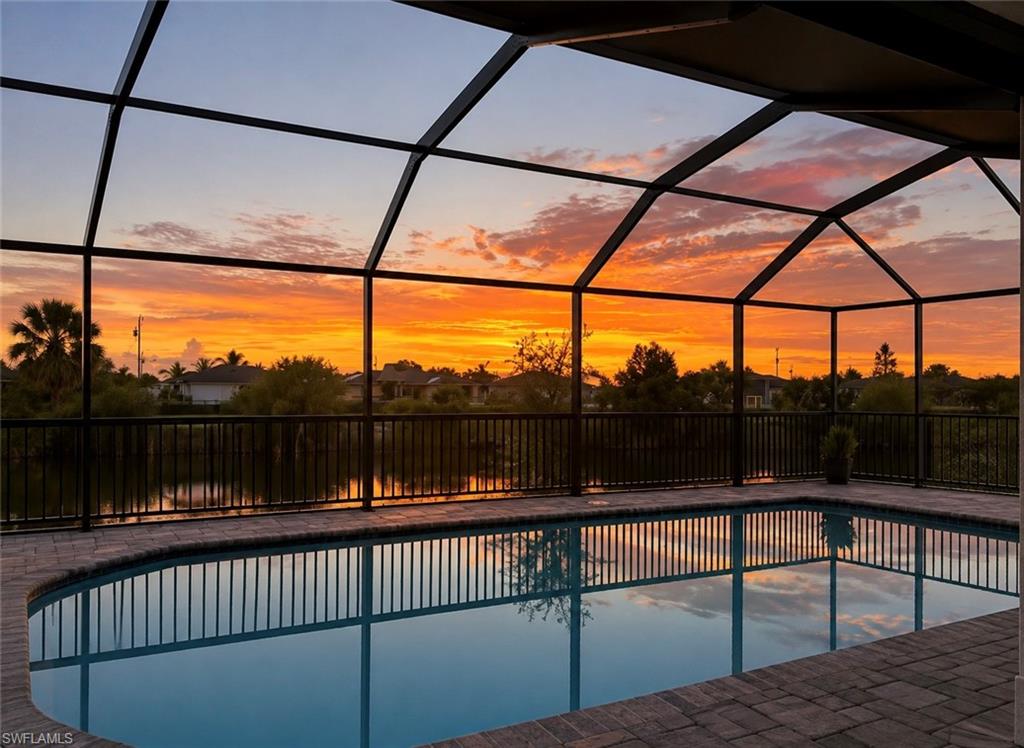 Screened enclosure featuring a pool and brick paver decking
