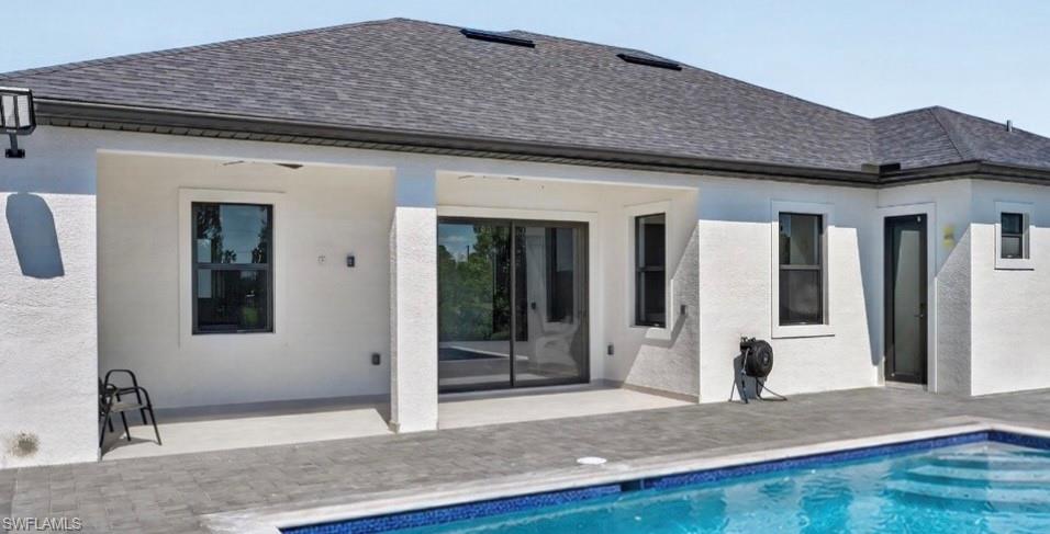 Exterior patio with a swimming pool featuring a patterned tile border