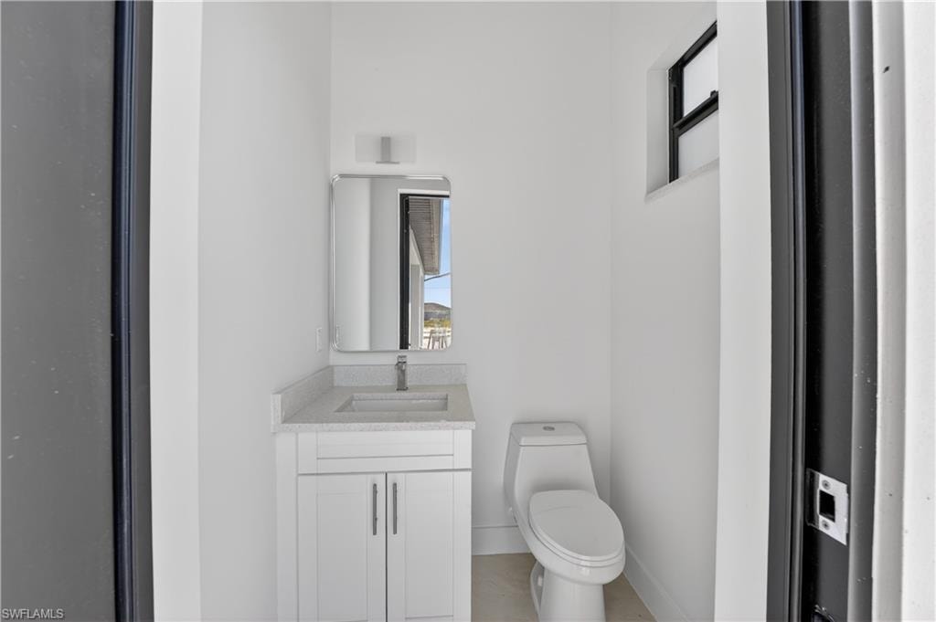 Bathroom featuring a white vanity with a light-colored countertop, an undermount sink, and a rectangular mirror
