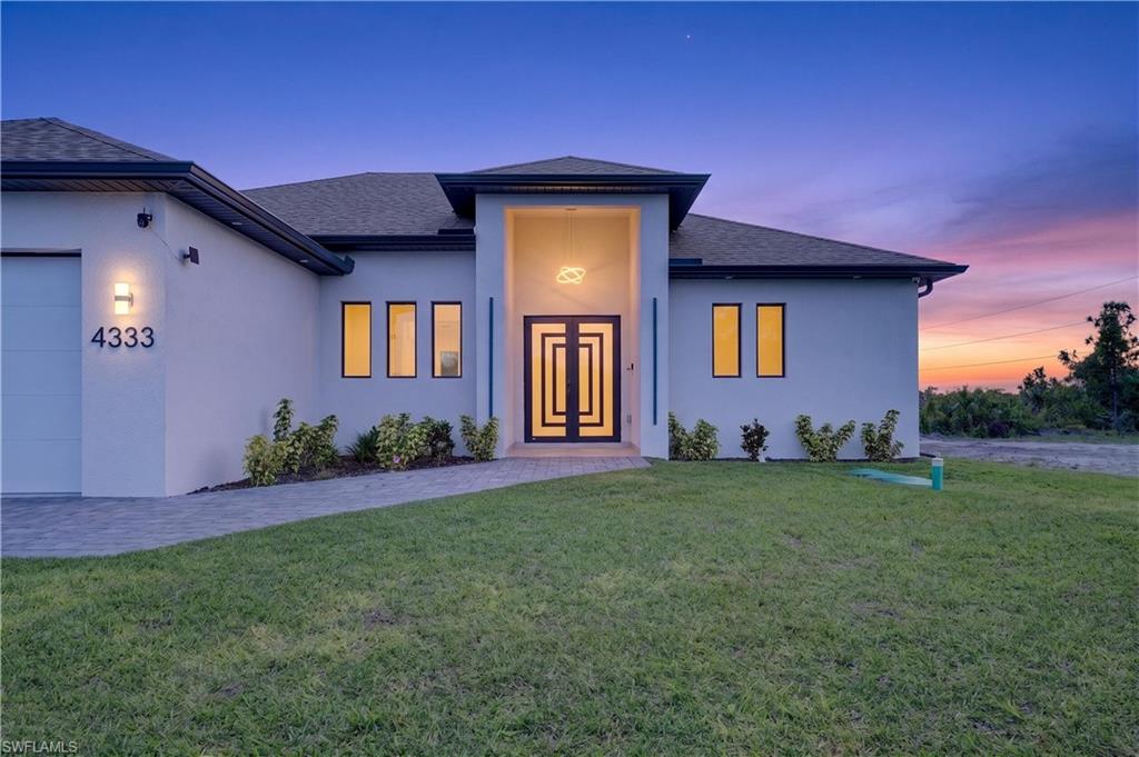 Modern stucco exterior with a prominent entryway featuring a geometric door design
