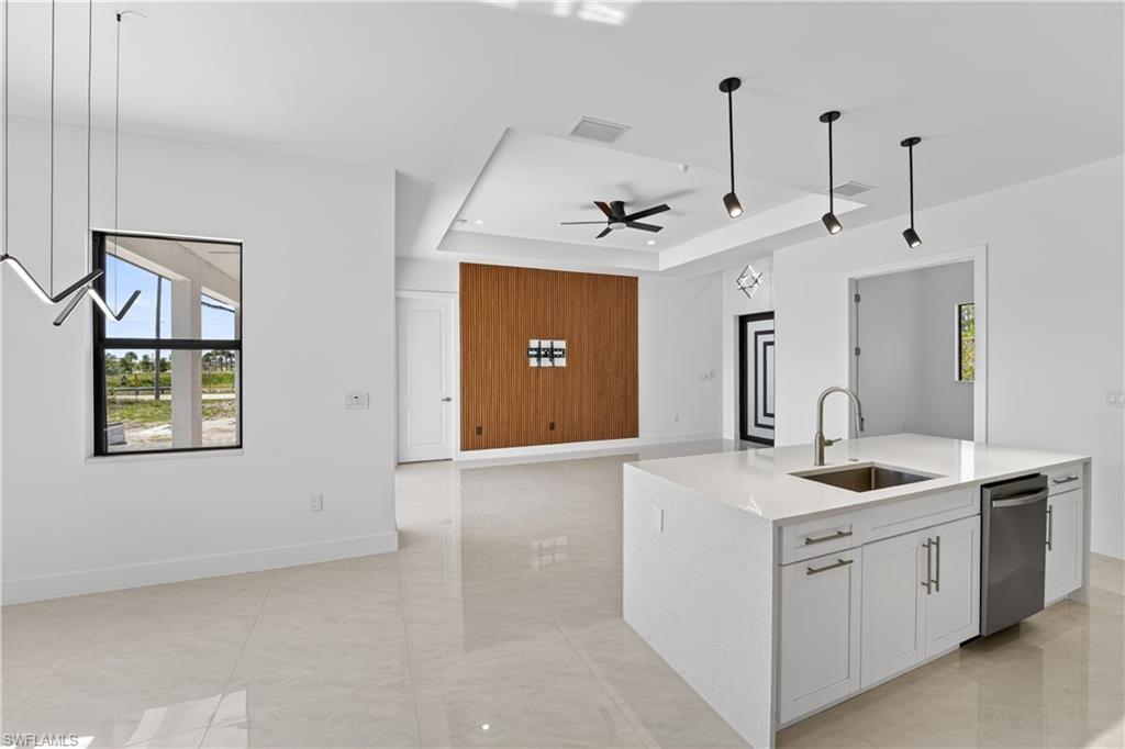 Kitchen island featuring a stainless steel sink, gooseneck faucet, and integrated dishwasher