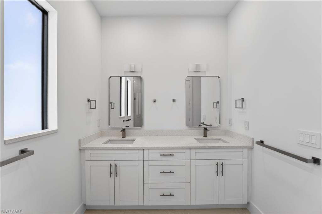 Dual vanity with light-toned countertop, integrated sinks, and matte black faucets