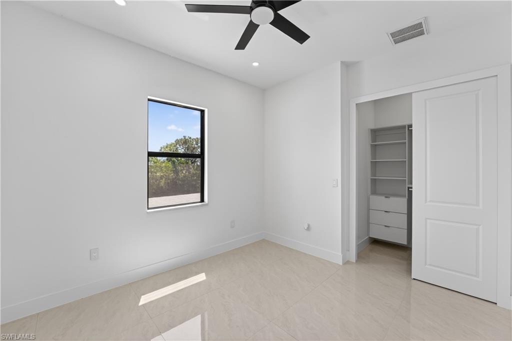 Bright interior space featuring light-toned tile flooring and white baseboards