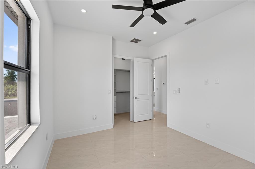 Room featuring light-toned tile flooring, a black ceiling fan, and recessed lighting