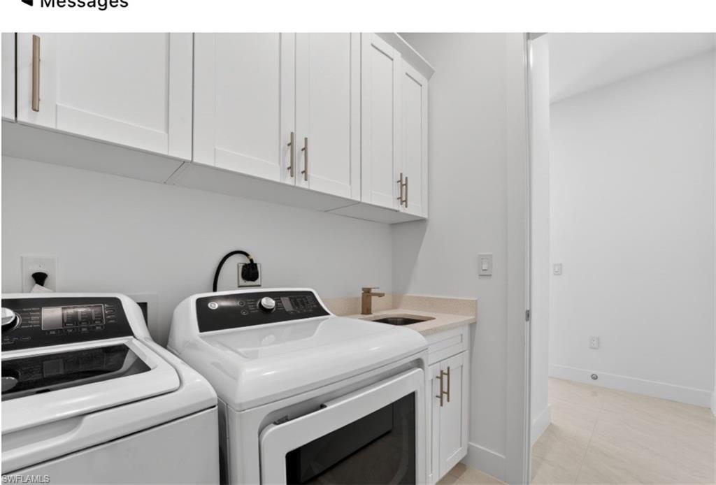 Dedicated laundry space featuring white shaker cabinetry with brushed brass hardware, a light-toned countertop, and a utility sink with a brass faucet