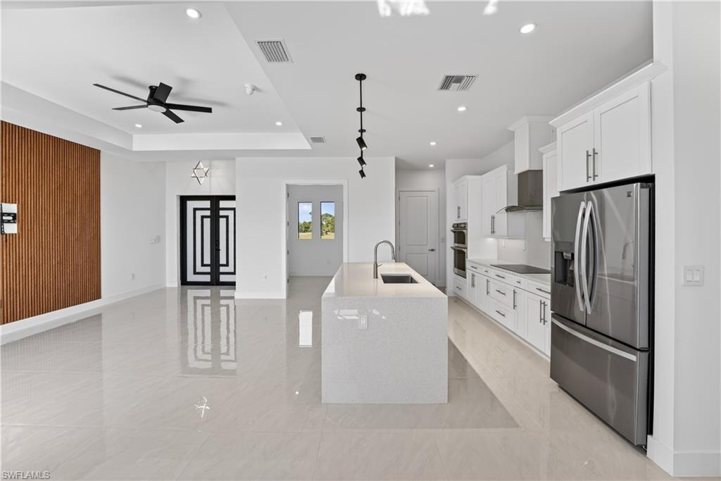 Open-concept living space with large format tile flooring and a modern kitchen