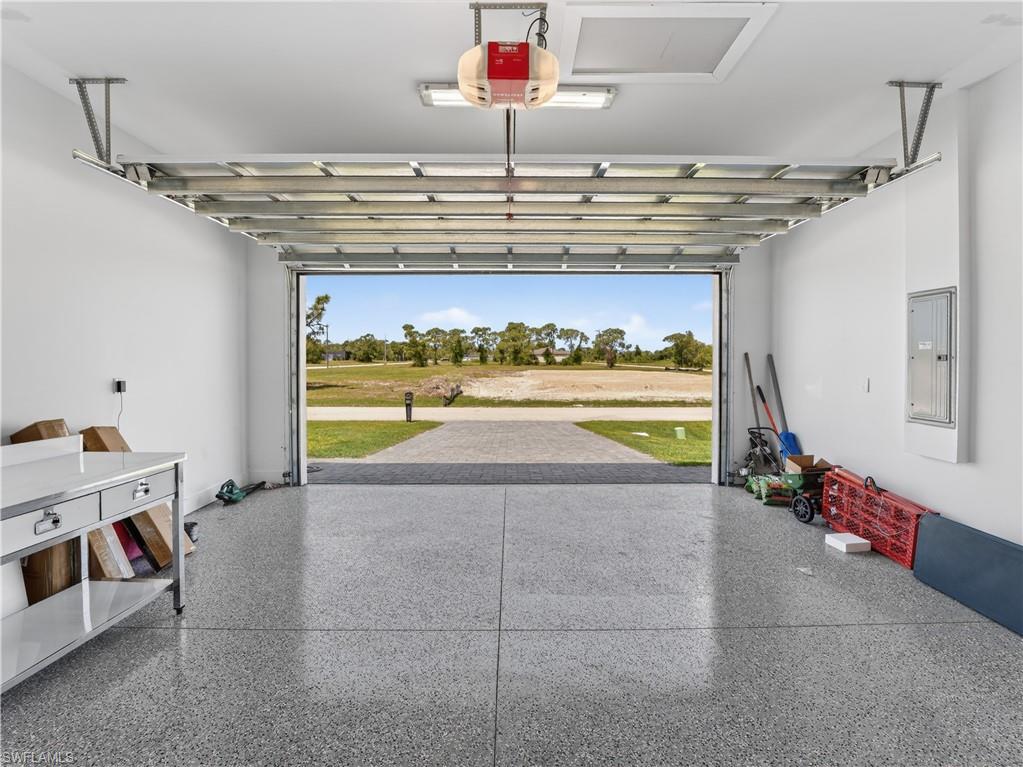 Garage featuring a speckled epoxy floor, white walls, and an overhead garage door opener